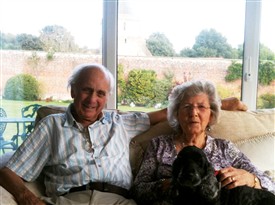 Photo:Bob and Barbara at home with the church in the background